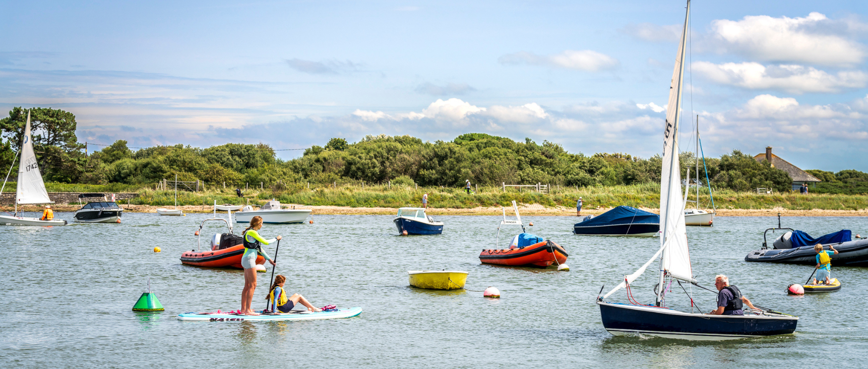 Two people paddleboard on the sea at Keyhaven, Hampshire